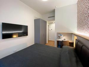 米兰Villino Milano的卧室配有一张床,墙上配有电视