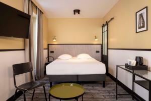 巴黎Hotel de l'Aqueduc的卧室配有1张床、1张桌子和1把椅子