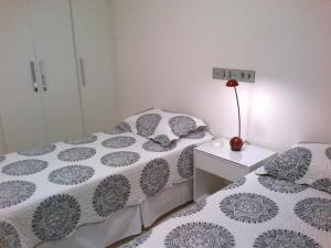 萨尔瓦多Apartamento em Ondina的一间卧室配有两张床和一张带台灯的桌子