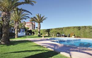 托雷维耶哈Stunning Home In Torrevieja With 3 Bedrooms, Wifi And Outdoor Swimming Pool的一座棕榈树游泳池,位于酒店大楼旁