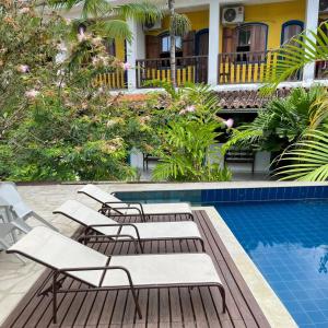 帕拉蒂Hotel Velejador的房屋旁带躺椅的游泳池