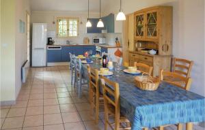 Saint-Pons-de-Mauchiens4 Bedroom Pet Friendly Home In St Pons De Mauchiens的一间带桌椅的厨房和一间带蓝色橱柜的厨房