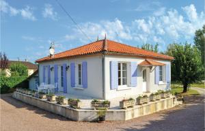 BassillacNice Home In Bassillac With Kitchen的白色的小房子,拥有蓝色的窗户和植物