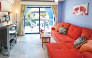 滨海罗克塔斯Nice Home In Roquetas De Mar With Kitchenette的客厅配有红色的沙发和桌子