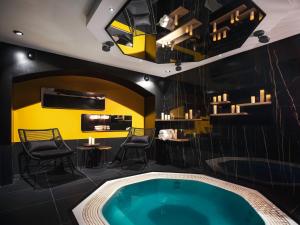 巴黎Love Hôtel avec nuit insolite au Dandy et Jacuzzi privatisé的黄色墙壁的房间内的热水浴缸