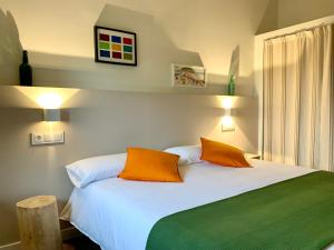 QuintesEL PILPAYO的卧室配有白色床和2个橙色枕头
