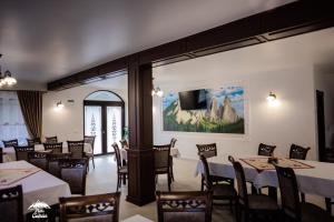 多尔纳-阿里尼Piatra Codrilor的餐厅设有桌椅和大窗户。