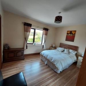 韦斯特波特Ros na gCloch的一间卧室设有一张大床和一个窗户。