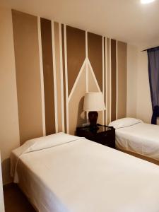 圣玛丽亚港阿拉哈海滩旅馆的一间卧室设有两张床和一张桌子上的台灯。