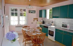 PleuvenNice Home In Pleuven With Wifi的厨房配有绿色橱柜和桌椅
