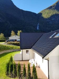 艾于兰Cheerful 4-bedroom home with fireplace, 1,5km from Flåm center的屋顶上设有太阳能电池板的白色房屋