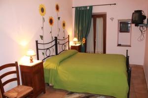 巴尼奥雷焦拉洛盖塔住宿加早餐旅馆的卧室配有一张带鲜花的绿色床。
