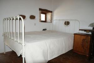AyiáAfrodite's House-Restaurated Oil Factory的卧室配有白色的床和木桌