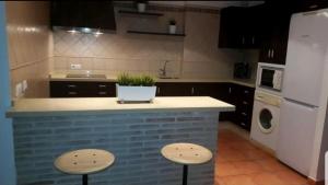 格拉茨莱马CASA MI SUEÑO的厨房配有带2把凳子的柜台和洗碗机。