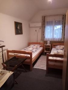 TiszaszőlősMézeskuckó的一间卧室设有两张床和窗户。