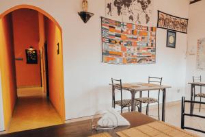 尼甘布莉莉宫别墅旅馆的一间设有橙色门、桌子和椅子的房间