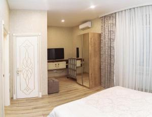 巴库MidCity Hotel的一间卧室配有一张床、一台电视和一扇门