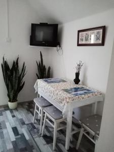 TiszaszőlősMézeskuckó的一张带椅子的白色桌子和墙上的电视