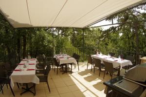 佩奇席拉皮亚酒店的庭院里的餐厅配有白色的桌椅