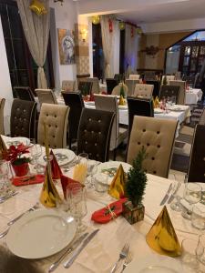 莫伊西德约斯Hotel boutique Garden Resort by Brancoveanu的一间设有白色桌椅的用餐室