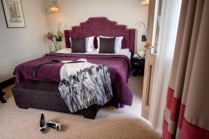 利沃夫阿斯托利亚酒店的一间卧室配有一张大床和紫色床罩