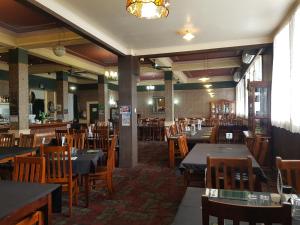达格维尔Northern Wairoa Hotel的用餐室配有桌子和木椅