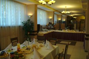卢布林鲁博林公寓式酒店的用餐室配有桌椅和食物