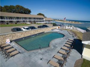 奥甘奎特Sea Chambers的一个带椅子的游泳池,酒店和大海