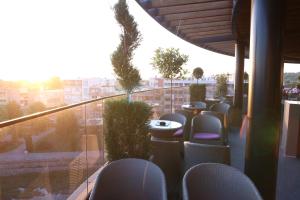帕拉钦Orbis Design Hotel & Spa的阳台配有桌椅,享有城市美景。