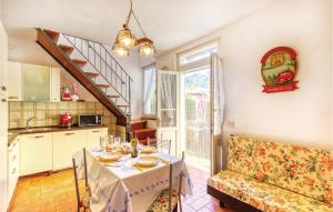 StazzemaCasa Tommasi的厨房以及带桌子和沙发的用餐室。