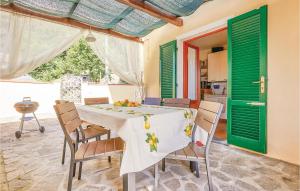 卡麦奥雷La Casa Dei Ricci的用餐室配有桌椅和绿色百叶窗