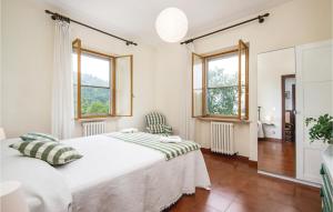 Bazzano InferioreAmazing Home In Spoleto With Wifi的一间卧室设有一张床和两个窗户。