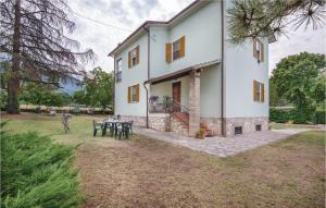 Bazzano InferioreAmazing Home In Spoleto With Wifi的一座大白色房子,在院子里设有桌子