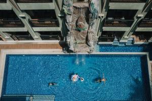 奥南海滩Ananta Burin Resort - SHA Extra Plus的两人在带水滑梯的游泳池游泳