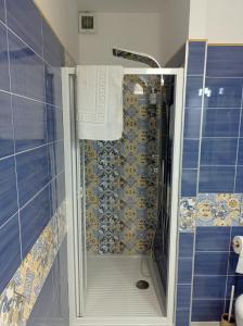 梅塔Caldi Abbracci的浴室设有蓝色瓷砖淋浴。