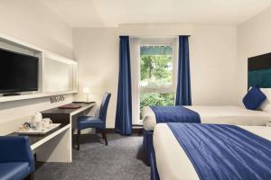 沃特斯道克牛津华美达酒店的酒店客房设有两张床和窗户。