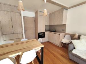 谷雪维尔Douglas - Appartement au cœur du Jardin Alpin的厨房以及带木桌和椅子的客厅。