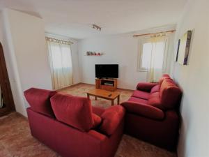 卡拉马奎达Cala Mesquida的客厅配有2张红色沙发和电视