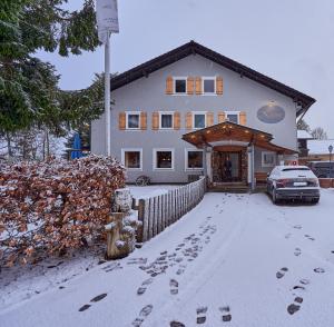 上罗伊特克朗乡村酒店的前面的雪地里有脚印的房子