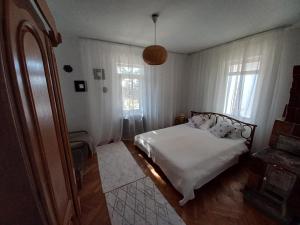 OveseluCasa de Vacanta Nora的一间卧室配有一张带白色床单和窗户的床。
