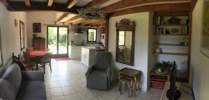 波讷地区圣朱利安Maison de vacances village Océlandes的厨房以及带沙发和桌子的客厅。