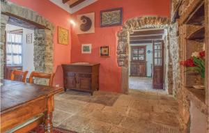 Comano1 Bedroom Beautiful Home In Comano ms的一间拥有橙色墙壁和木桌的房间