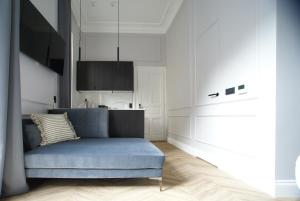 萨格勒布Fingerprint Luxury Apartments 3的一间带蓝色沙发的客厅和一间厨房