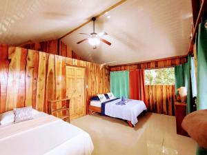 德雷克The Sunset Tucano Lodge的一间卧室配有两张床和吊扇