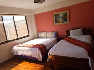 拉巴斯Hostal La Posada De La Abuela的红色墙壁客房的两张床