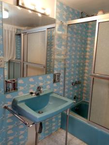 拉巴斯Hostal La Posada De La Abuela的浴室配有蓝色水槽和浴缸。