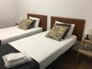 波尔图TMJ住宿加早餐旅馆的配有2张床的带白色床单和枕头的客房
