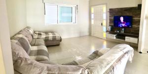 卡庞达卡诺阿Casa em Capao的带沙发和电视的客厅