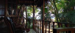 阿贡达Constantina Huts的客房设有带椅子和棕榈树的阳台。
