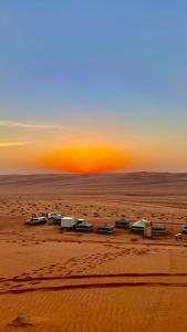 BadīyahSandGlass Camp的日落时分沙漠中的一群房子